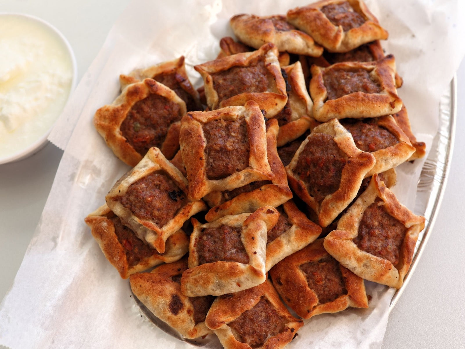 https://www.beckandbulow.com/cdn/shop/articles/Middle-Eastern-Style-Open-Faced-Meat-Pies-With-Lamb-Sfeeha-Beck-Bulow_1_1600x.jpg?v=1678889750